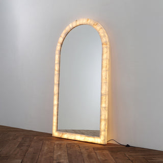angle view of Calista arched oversized floor mirror with soft ambient glow and natural wabi-sabi style on wood floor
