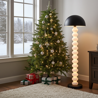 Calista sculptural floor lamp glowing beside a Christmas tree in a modern living room, cozy holiday lighting
