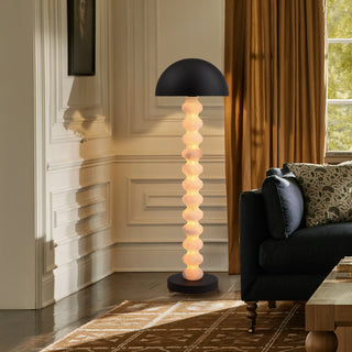 Calista sculptural floor lamp next to a sofa in a contemporary living room, warm ambient modern lighting