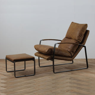 angle view of whiskey leather lounge chair  and ottoman with steel base on wood floor