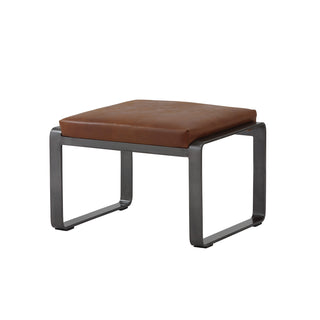 angle view of light brown leather lounge footstool with matte metal base
