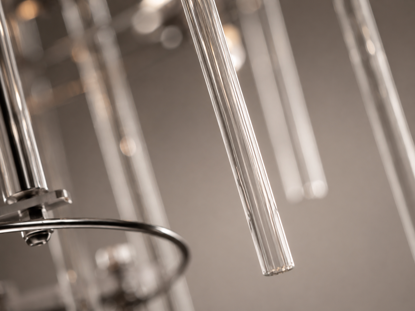 Detailed view of the Aura rectangular chandelier’s individually suspended clear glass rods and polished chrome accents.