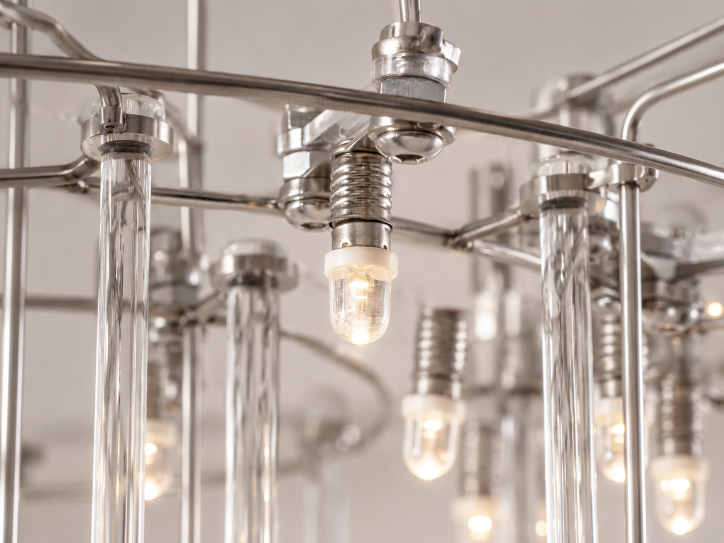 Aura rectangular chandelier detail showing small LED bulbs suspended among clear glass rods and polished chrome hardware.