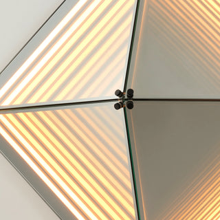 Close-up of the Axis LED Infinity Glass Mirror featuring warm linear LED lighting and reflective panel intersections.