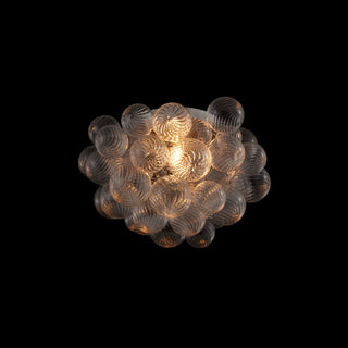 Bubble glass flush mount on black background, cluster of glowing glass orbs, light on
