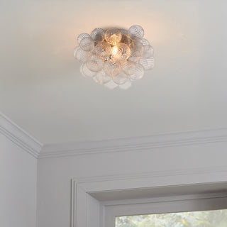 Bubble glass flush mount ceiling light installed in a hallway, warm modern ambient lighting