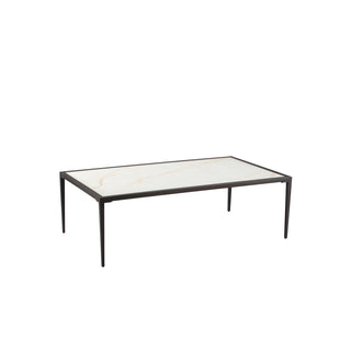 Angled view of small white stone coffee table with minimalist metal legs