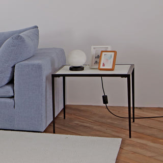 living room setup with calcite side table beside sofa, moonlit table lamps and decors