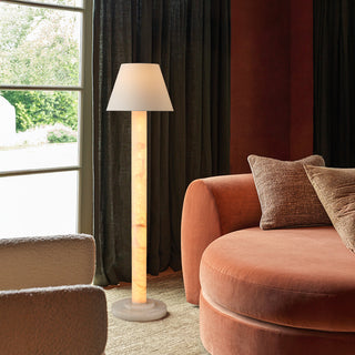 Calista floor lamp beside an accent chair in a contemporary living room, warm ambient corner lighting