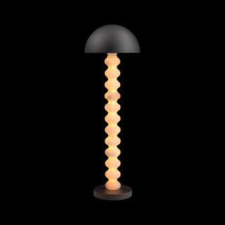 Calista sculptural floor lamp with stacked column and dome shade on black background, light on
