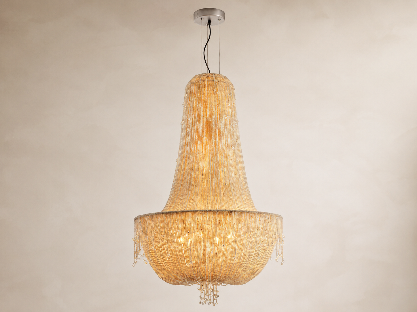 Full view of the Cascade empire chandelier with cascading glass beads illuminated against a neutral background
