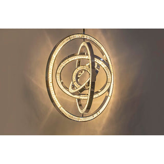 Close up of Celestial Orbit chandelier in warm brass finish, glowing concentric rings modern chandelier