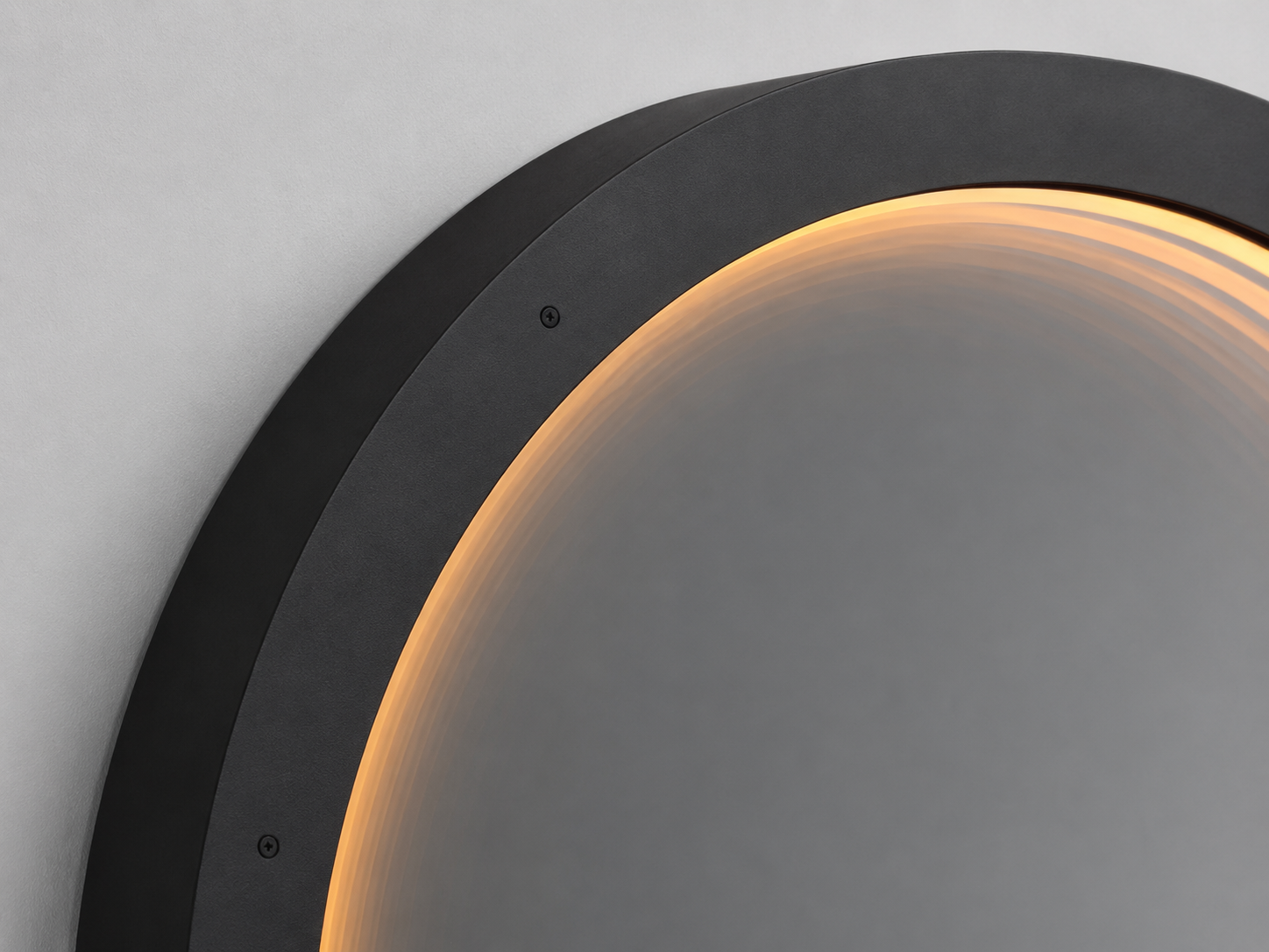 Angled close-up of the Eclipse round black-framed mirror with warm integrated LED illumination