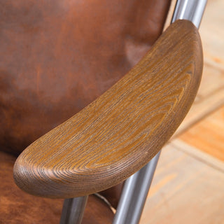 close-up detail of armrest joint and hand-stitched leather cushion in light brown and metal frame