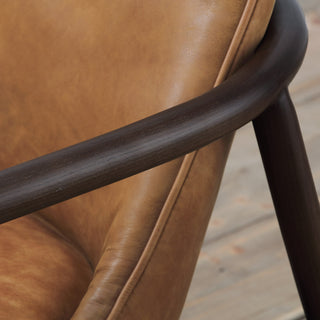 close-up detail of cognac leather stitching and natural wood joinery frame