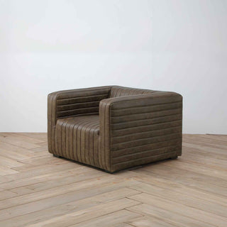 angle view of 1-seater ribbed leather armchair in warm whiskey brown color, light wood flooring