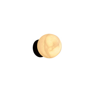 Moonlit Sconce wall light featuring a natural selenite stone globe and matte black base, glowing warmly against a white background
