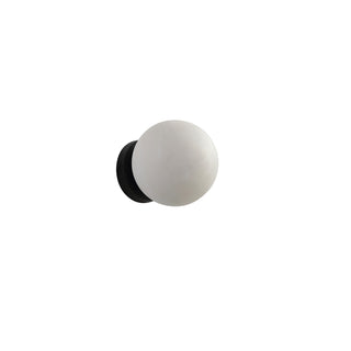 Moonlit Sconce wall light featuring a natural selenite stone globe and matte black base in a white background