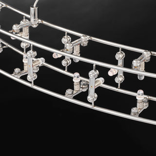 Unlit close-up of the Aura halo frame, paired inner and outer rails with bolted brackets holding the small bulbs