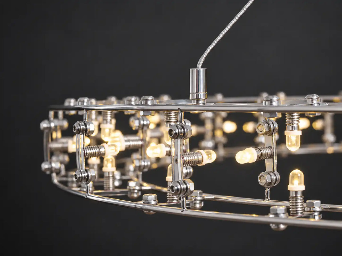 LED ring chandelier detail showing curved steel rails, threaded bulb holders and exposed metal connectors.