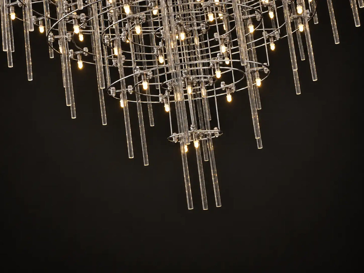 Aura Round Tiered Glass Rod Chandelier, low-angle view: dozens of clear glass rods, each with a warm LED, like stars overhead — ambient LED lighting