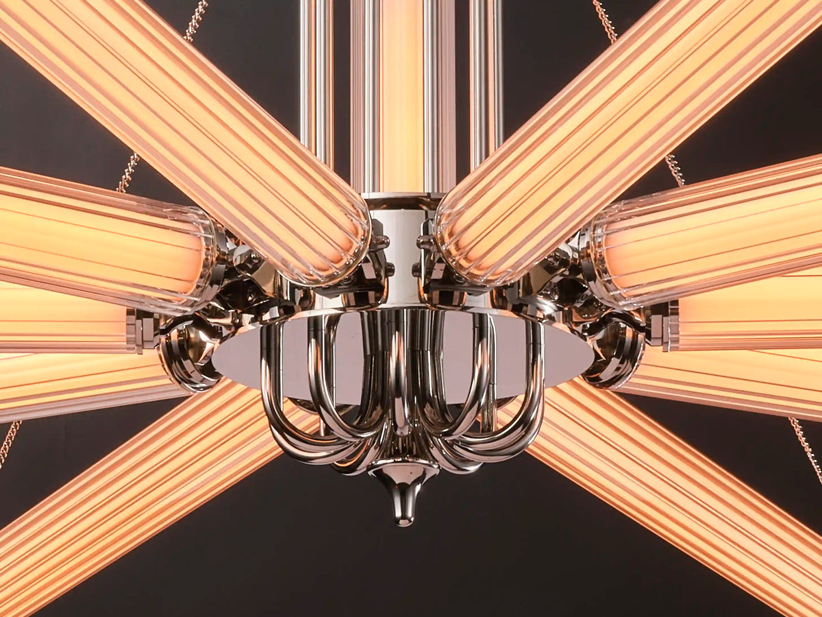 Underside detail of the chandelier’s polished nickel hub surrounded by glowing ribbed glass arms.