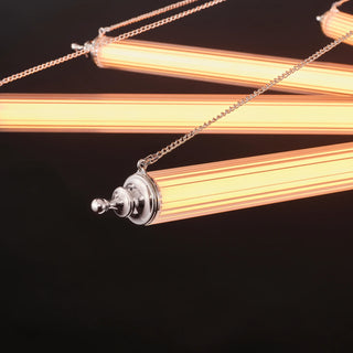 Close-up of illuminated ribbed glass tube arms with polished nickel end caps and adjustment chains on the Aurora chandelier.
