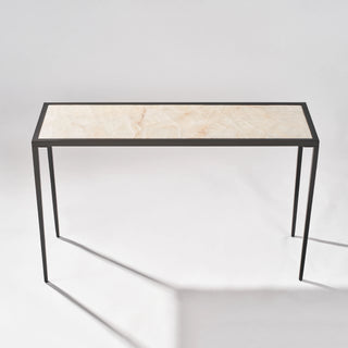 Elevated front view of the calcite console table showing the full stone top and rectangular black frame.