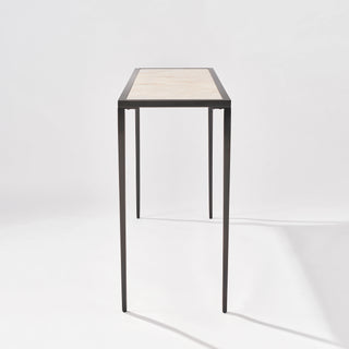 Low end view of the calcite console table showing the narrow tabletop depth and slim black legs.