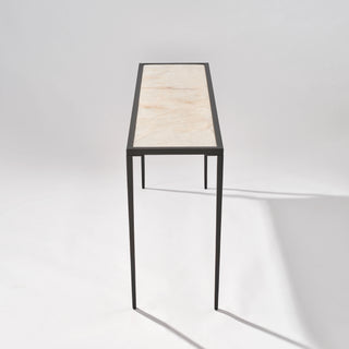High end view of the calcite console table showing the veined stone top extending along the slim black frame.