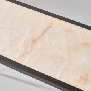 Close-up of the natural calcite tabletop showing its cream tones, subtle veining, and narrow black border.