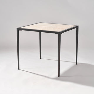 Opposite three-quarter view of the calcite side table showing its square proportions and naturally veined stone top.