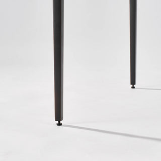 Lower view showing the spacing and straight profile of the calcite side table’s slim black legs.