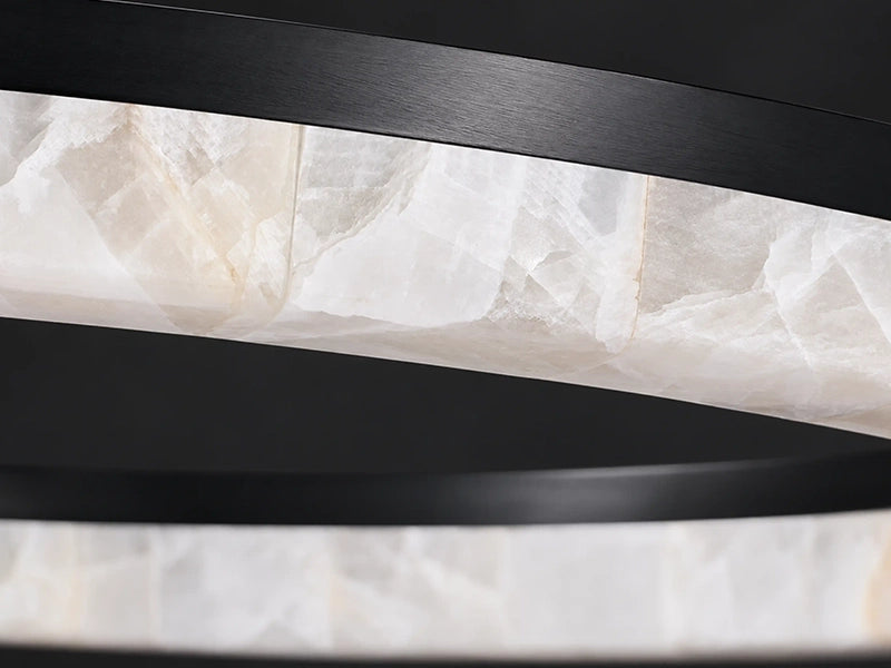 Close-up of the Calista chandelier's unlit calcite panels with natural white and gray veining. Natural stone ring chandelier