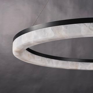 Close-up of the unlit Calista chandelier showing pale calcite panels, natural veining, and panel-to-panel variation.