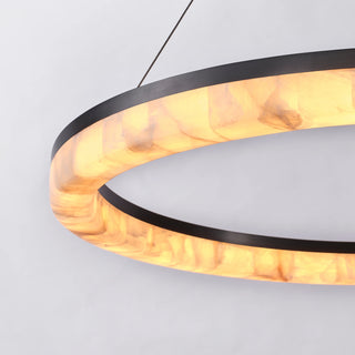 Illuminated calcite panels glowing within the Calista chandelier’s matte black ring against a white background.