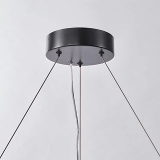 Close-up of the Calista chandelier’s round matte black canopy, suspension cables, and clear power cord.