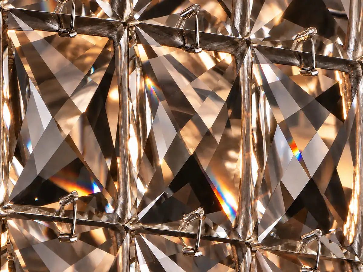 Close-up of faceted K9 crystals on the Lattice lighting collection, showing precise cuts and warm light reflections.