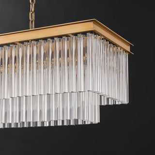 Unlit corner detail of the Marais 60-inch rectangular glass chandelier on a dark background, showing the clear glass rod tiers and brass-finished frame.