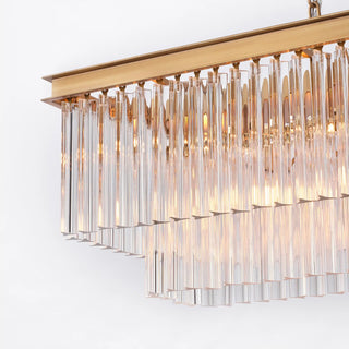 Illuminated side detail of the Marais 60-inch rectangular glass chandelier on a white background, showing warm light passing through tiered clear glass rods.
