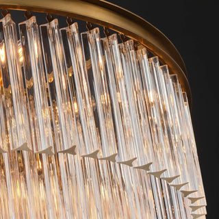 Warm light shines through the Marais chandelier's clear glass rods beneath a ring in Aged Brass finish.