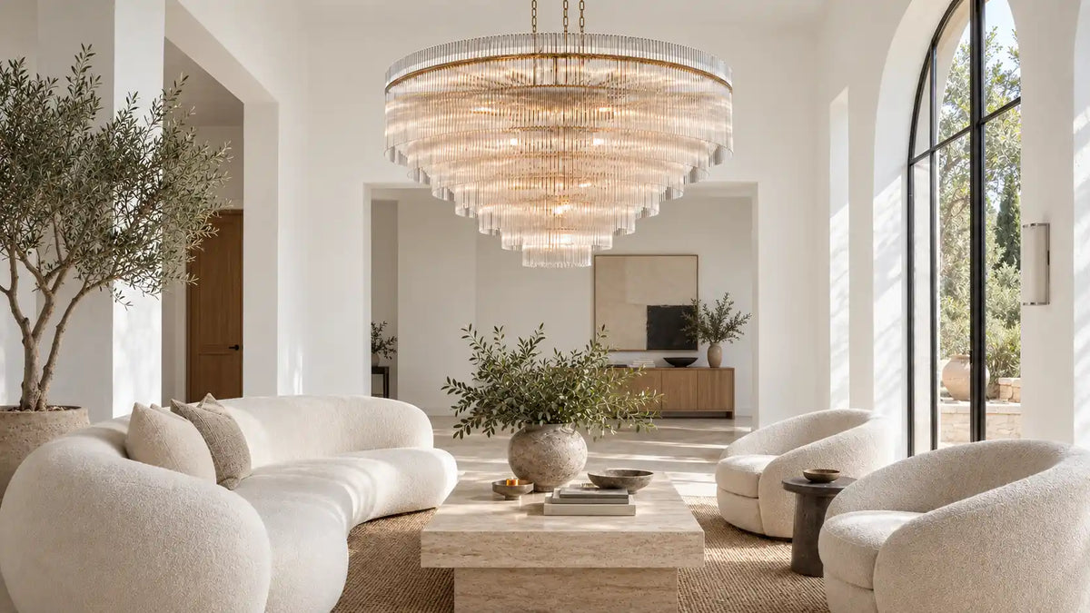 Timelore tiered glass rod chandelier glowing above ivory seating and a travertine coffee table in a modern Tuscan living room with white walls.
