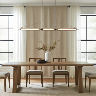 Bright dining room with wooden table and chairs by tall windows — styled interior