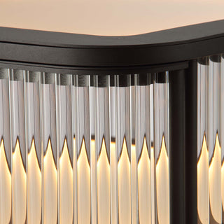 close-up top view of illuminated bar matte black metal frame cabinet with fluted glass and warm LED lighting