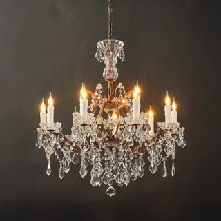 Warmly lit Moorizon Rustline 12-light crystal chandelier full view with candle-style lights, ornate iron frame, and cascading crystals on a black background