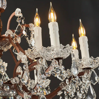 Warmly lit Moorizon Rustline 12-light crystal chandelier detail with candle-style bulbs, curved iron arms, and hanging crystal accents on a black background