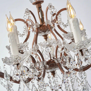 Unlit Moorizon Rustline 12-light crystal chandelier detail with curved iron arms, crystal drops, and decorative candle sleeves on a white background