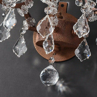 Unlit Moorizon Rustline 3-light wall sconce detail showing layered crystal drops, antique metal frame, and dark background