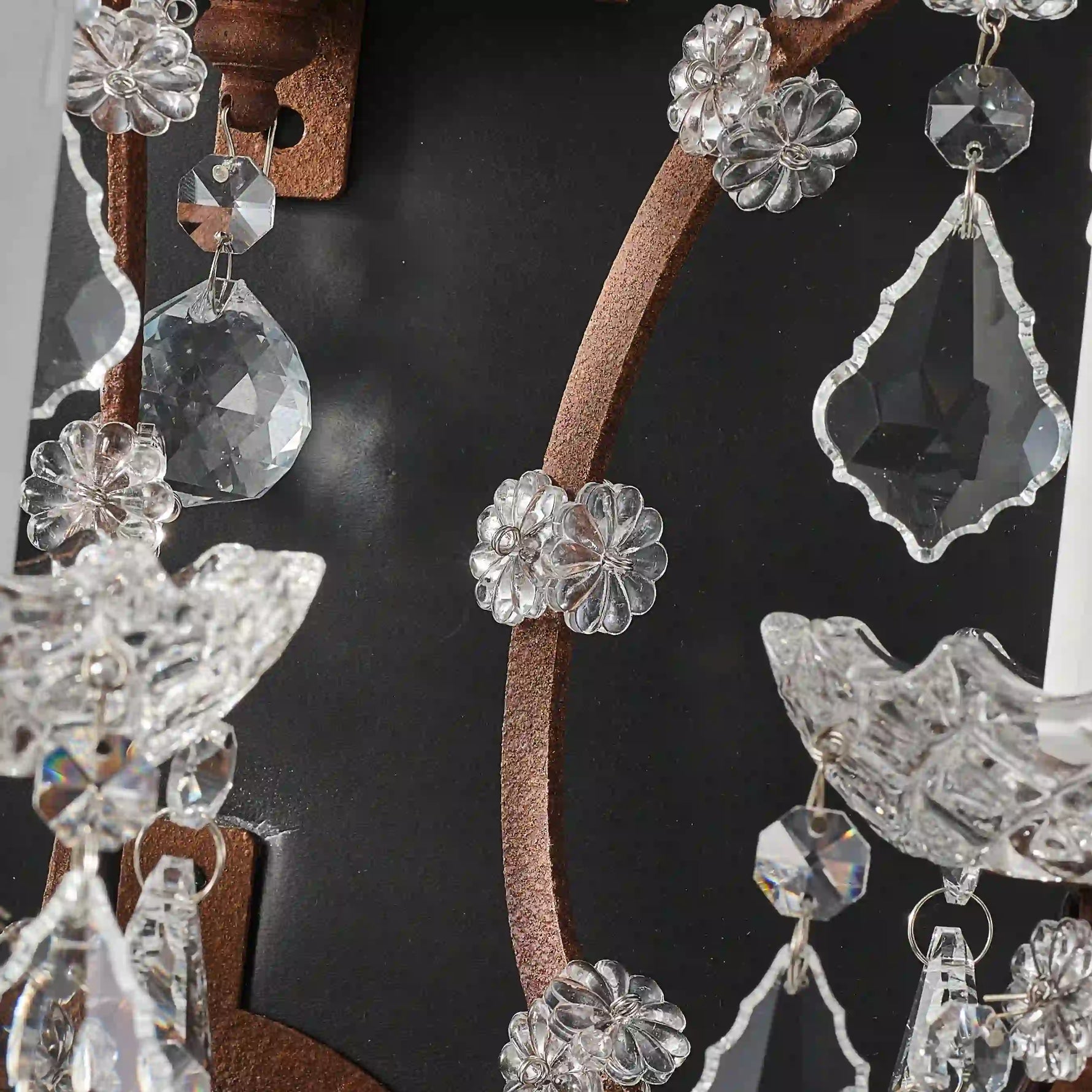 Unlit Moorizon Rustline 3-light wall sconce detail showing faceted crystal strands, antique-style metal arms, and dark background