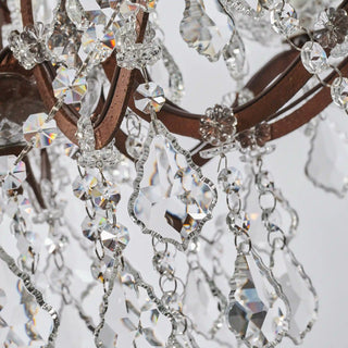 Unlit Moorizon Rustline 12-light crystal chandelier detail showing faceted crystals, decorative chains, and antique-style iron arms on a white background